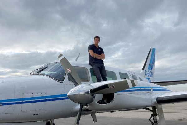 ϲʿѯ alum Joey Rood standing by an airplane