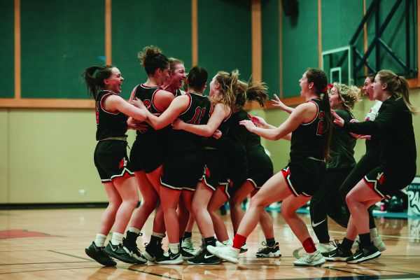 The ϲʿѯ Coyote's women's basketball team coming together for a group hug.