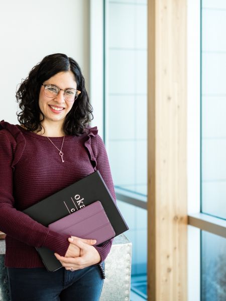 Female business admin diploma student holder an ϲʿѯ binder and an ipad ready to go to class.
